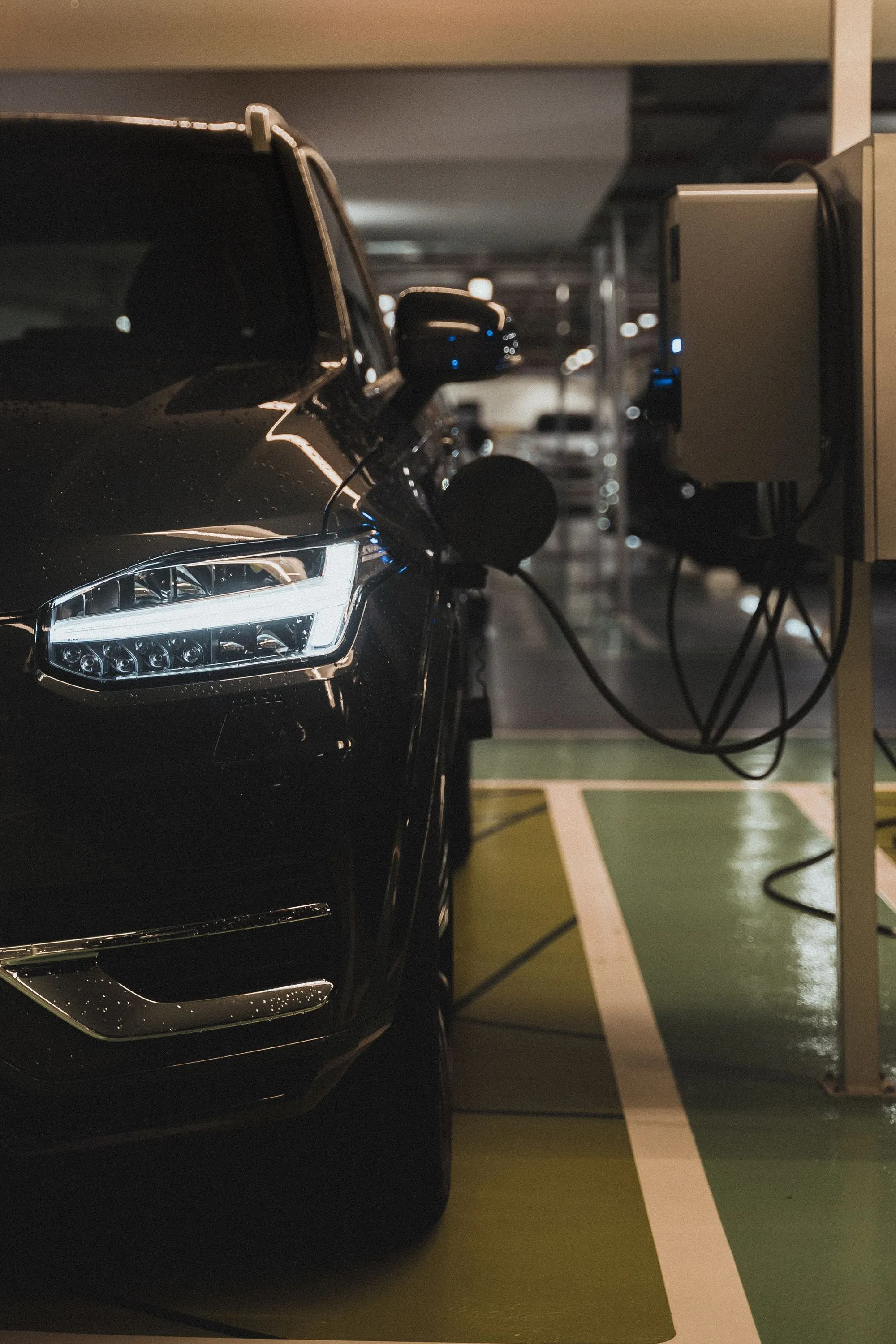Voiture électrique en charge sur une borne murale dans un parking couvert