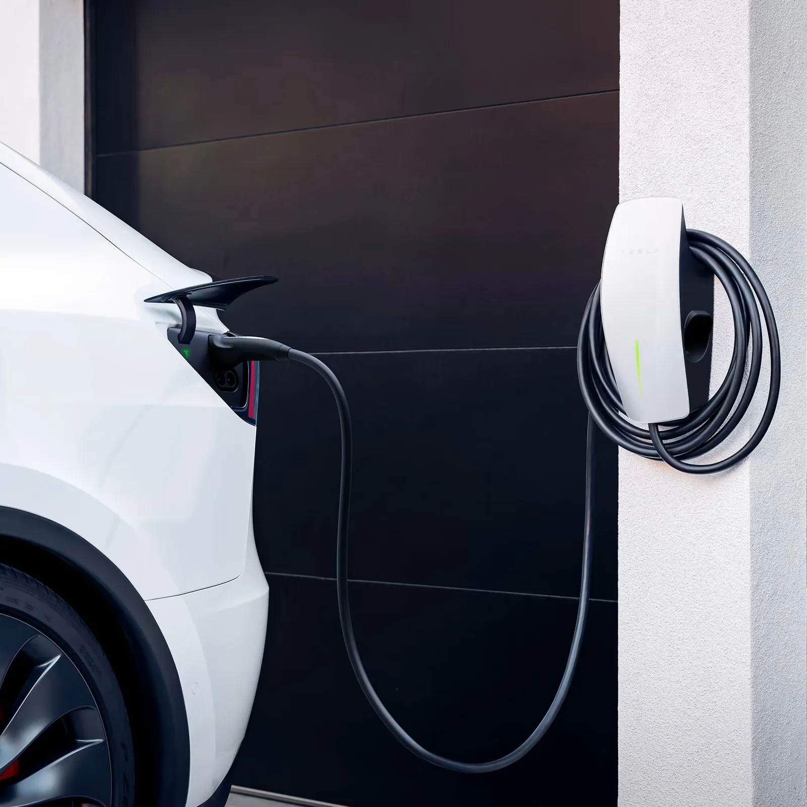 Borne Tesla Wall Connector murale branchée sur une voiture blanche