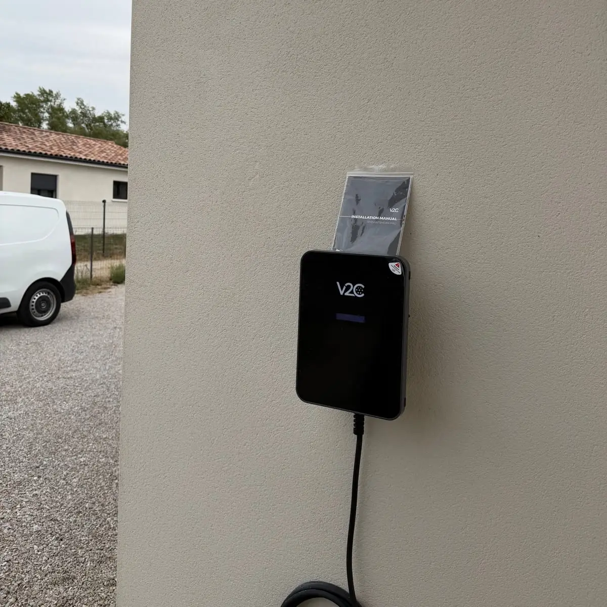 Borne de recharge V2C Trydan posée par Electro Borne sur le mur extérieur d’une maison